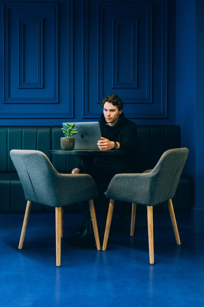 man on computer in blue room