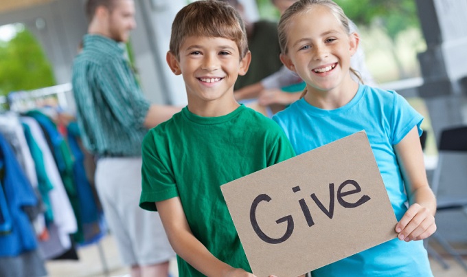Kids holding a "Give"" sign