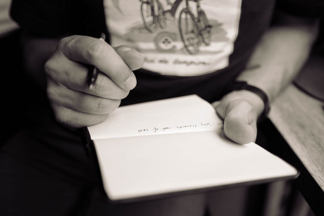 man taking notes in notebook