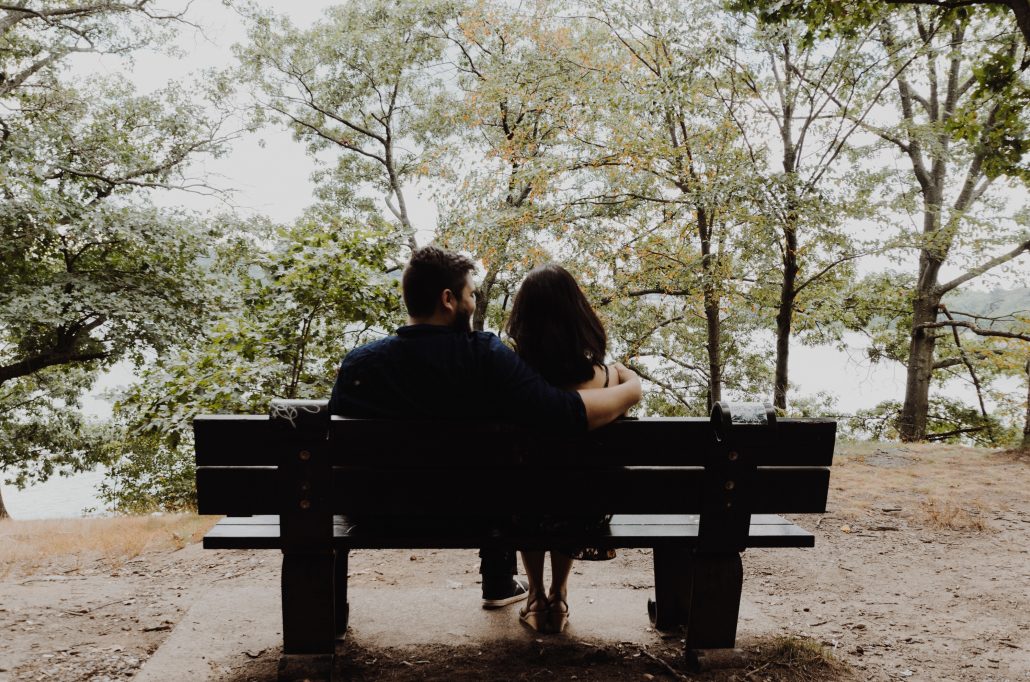 Couple sitting on bench talking about will