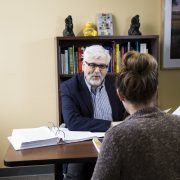 Gordon Fischer at desk with client