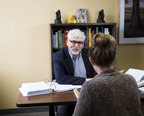 Gordon Fischer at desk with client