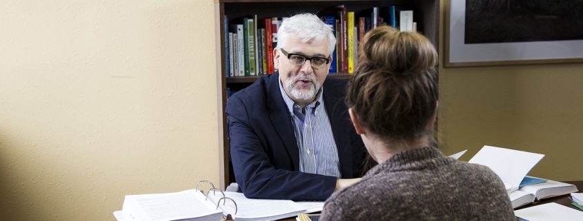 Gordon Fischer at desk with client