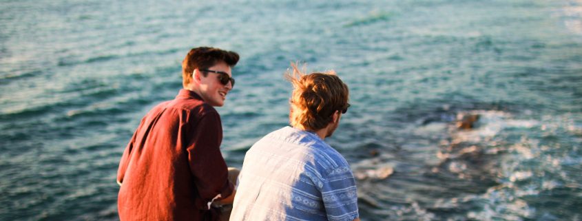 Two men having a conversation near the ocean