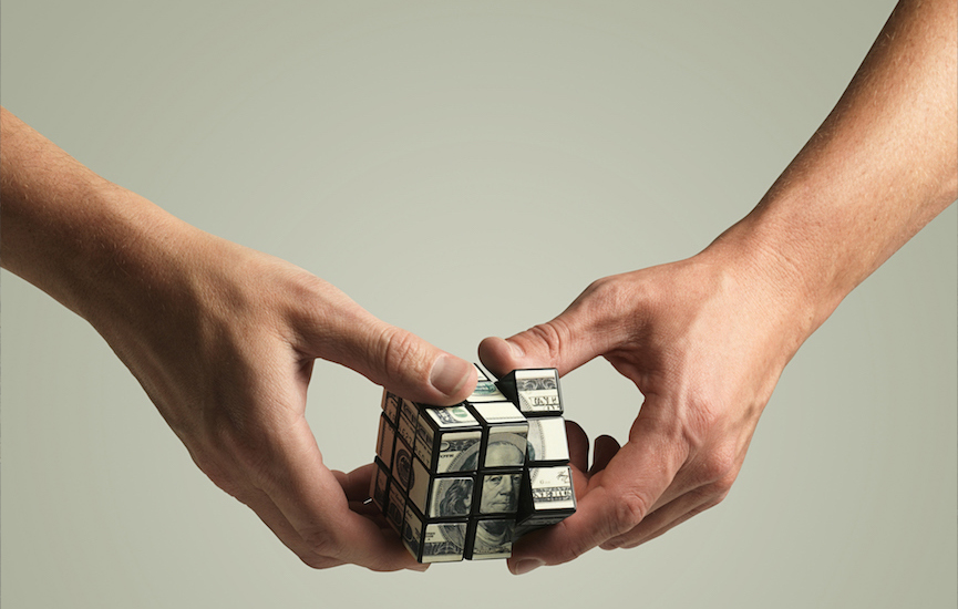 Money Rubix cube being twisted by haneds