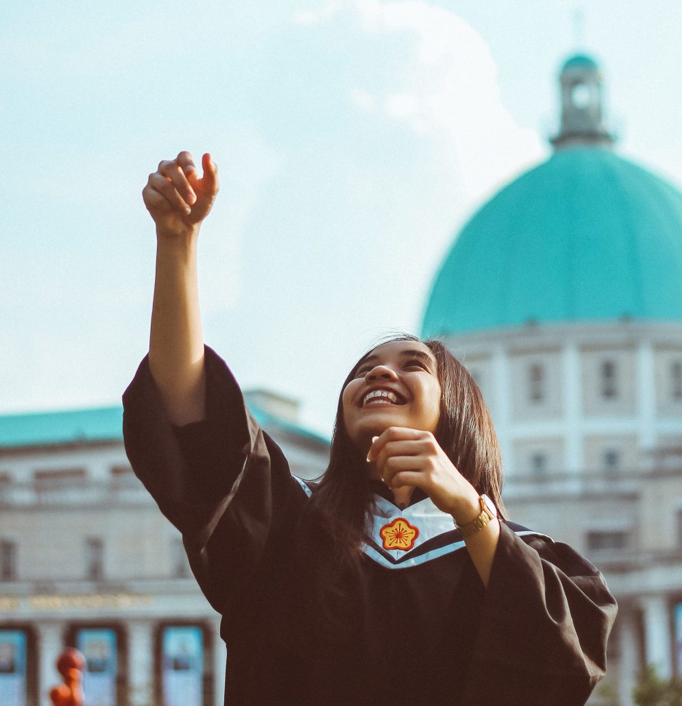 College student tossing cap into air