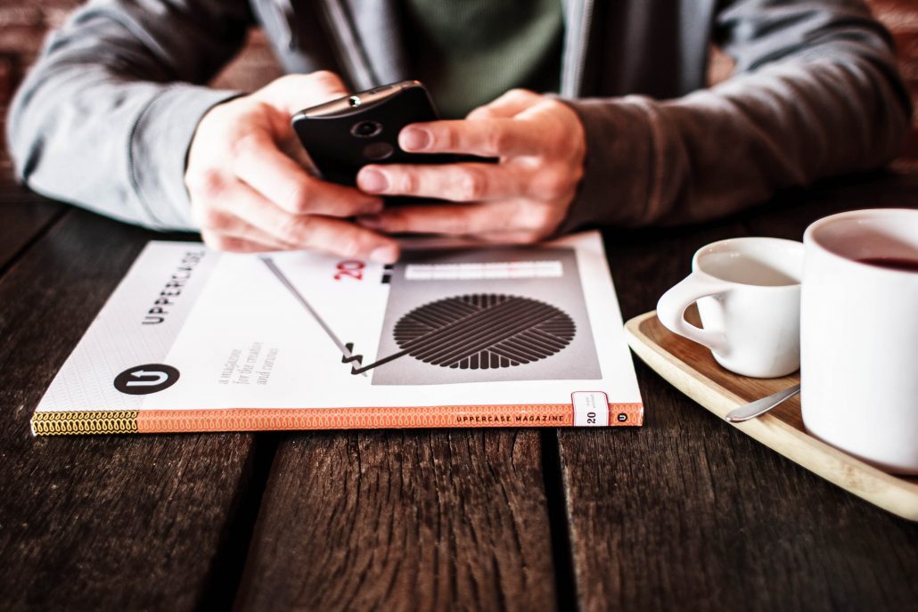 Person holding phone at table