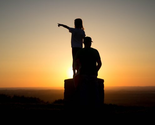 Someone pointing into the sunset