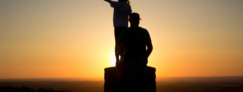 Someone pointing into the sunset