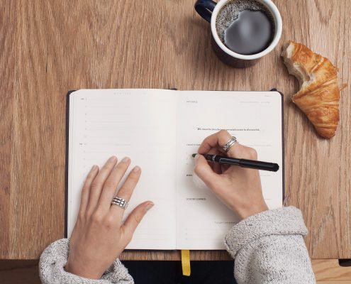 Checklist with coffee and croissant
