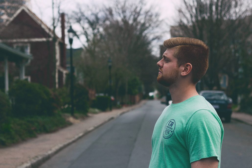 Man in street looking at house