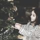 Girl hanging ornaments on tree