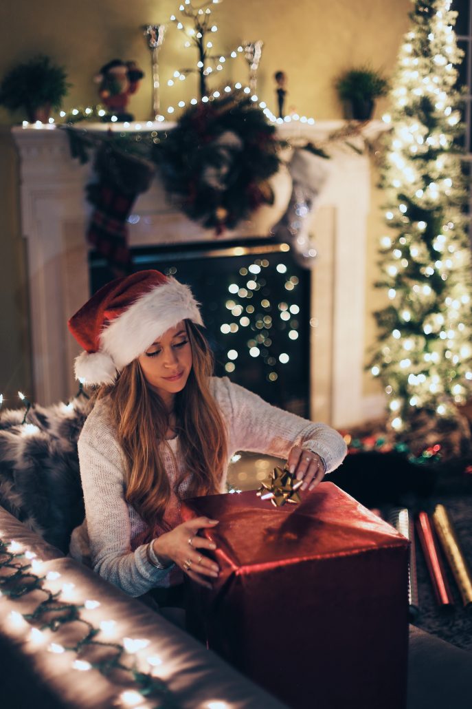 woman opening gift on couch