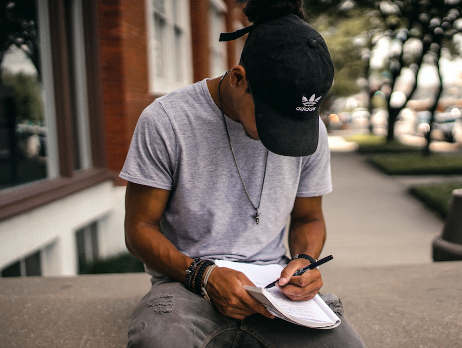 man writing down ides in notebook