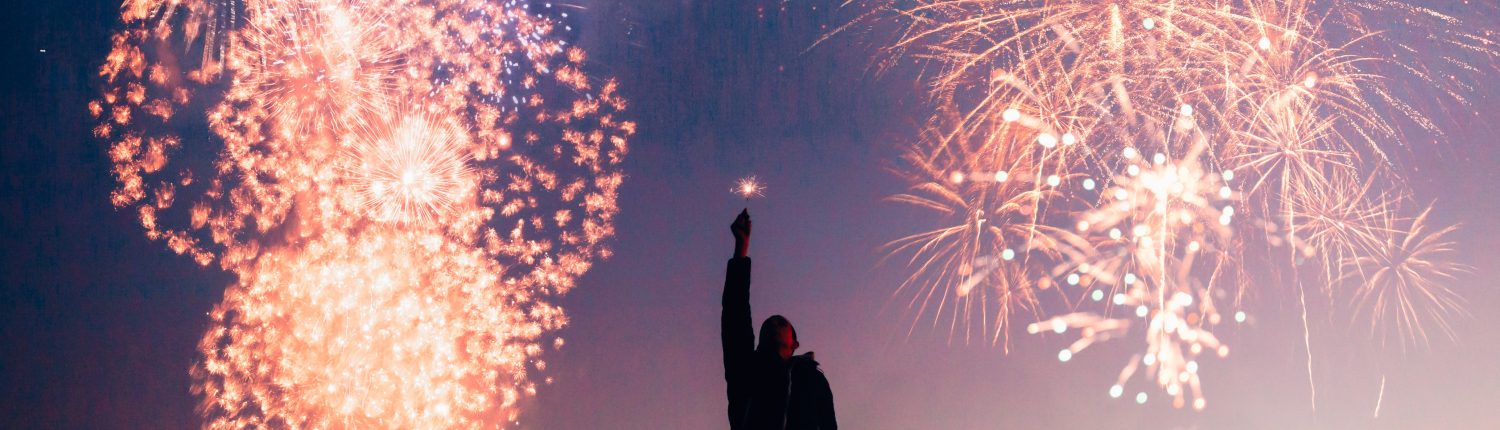 fireworks with man reaching up to the sky