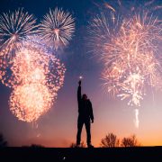 fireworks with man reaching up to the sky