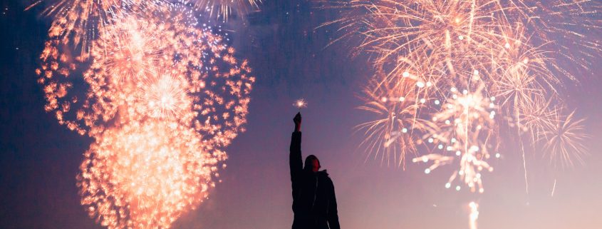 fireworks with man reaching up to the sky