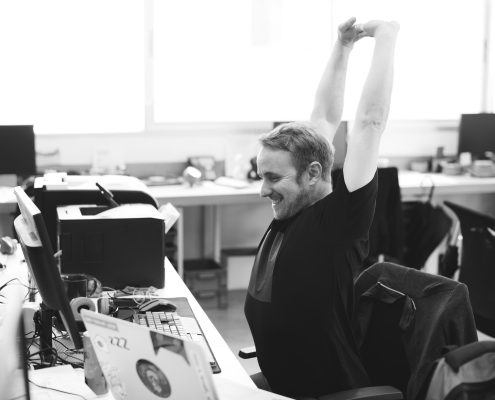 man stretching at desk