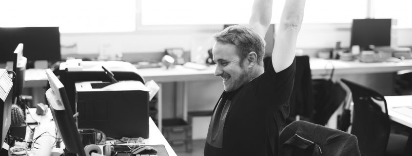 man stretching at desk