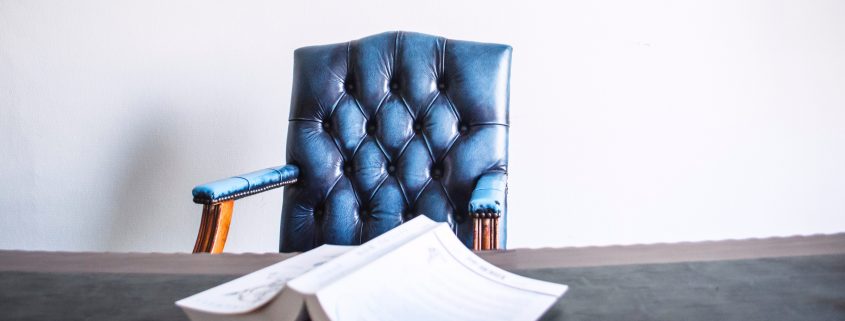 Conflict of Interest chair with book on table