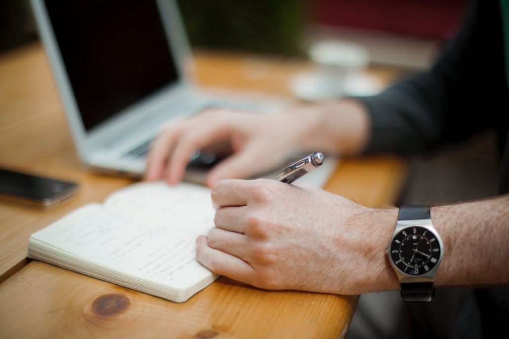 man writing on paper