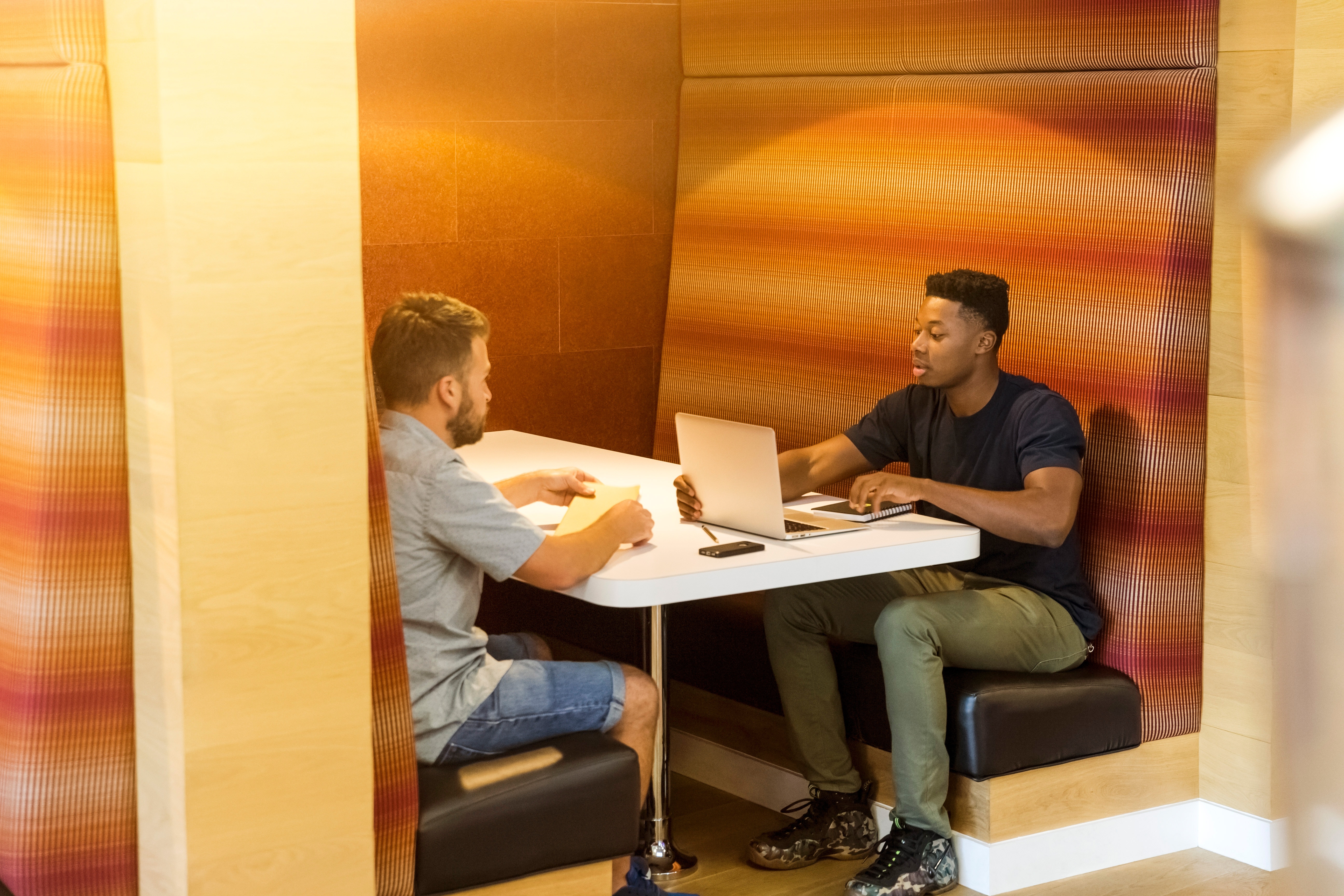 two men talking in booth