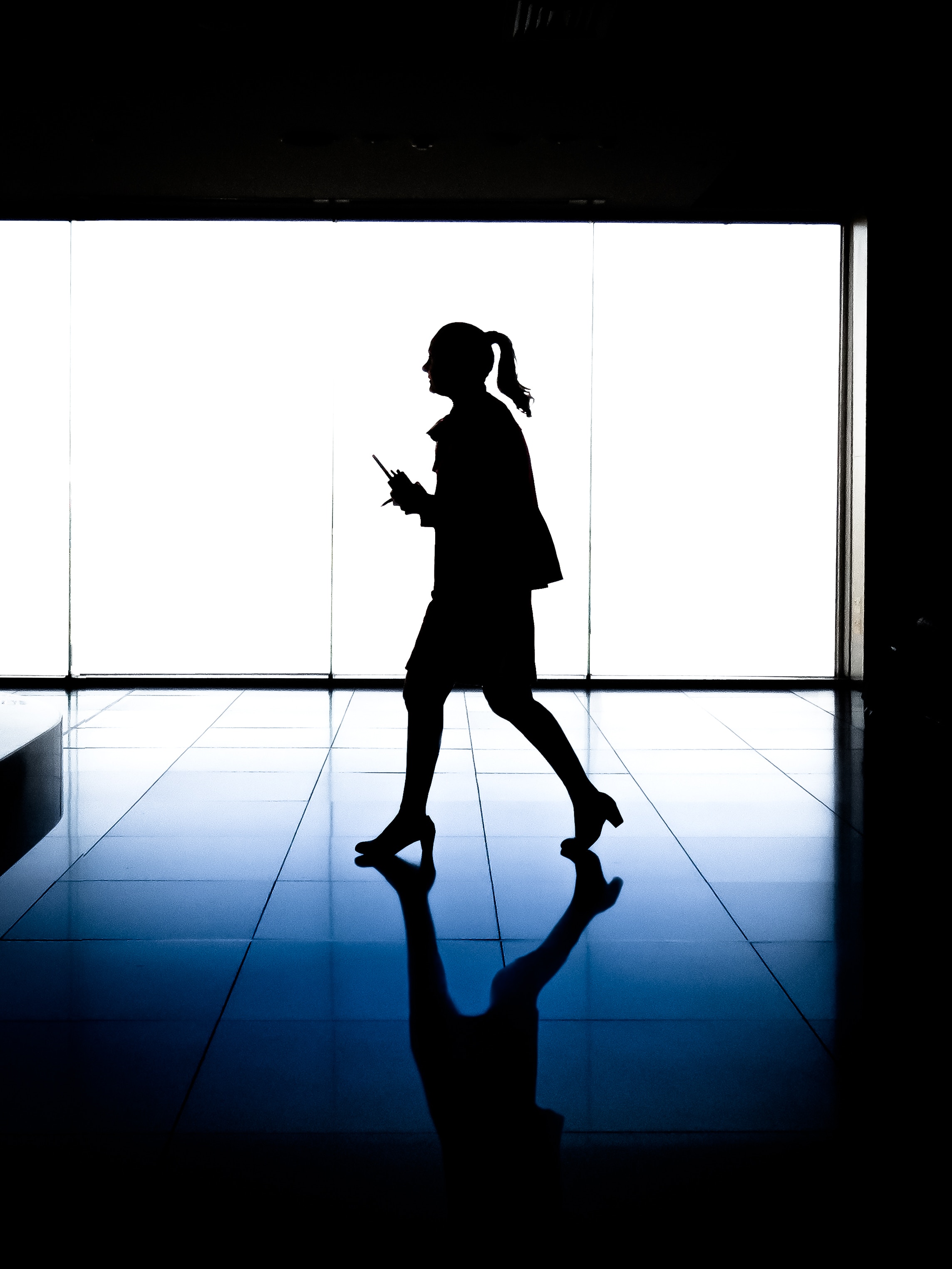 woman walking against blue window