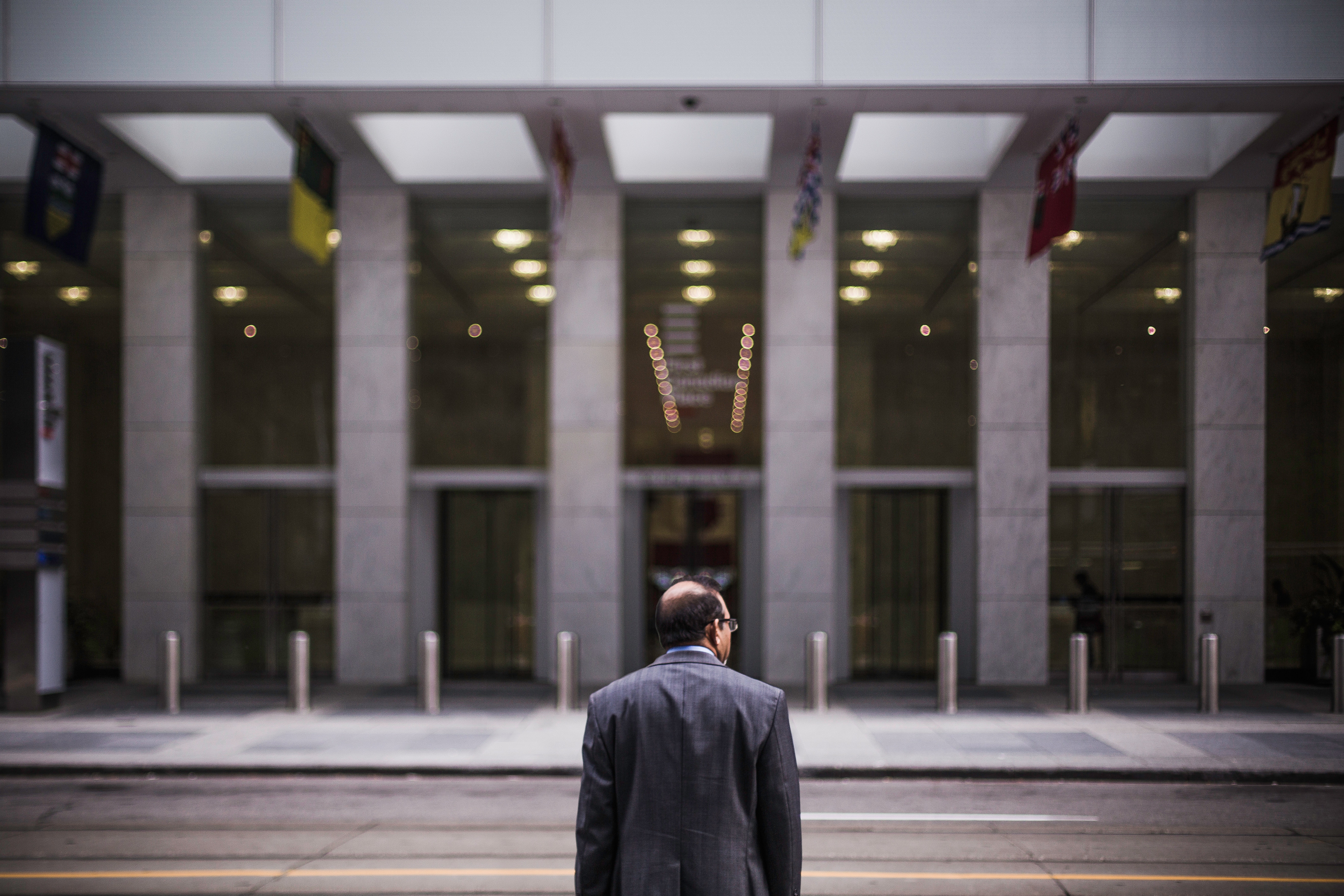 Man looking at grey building