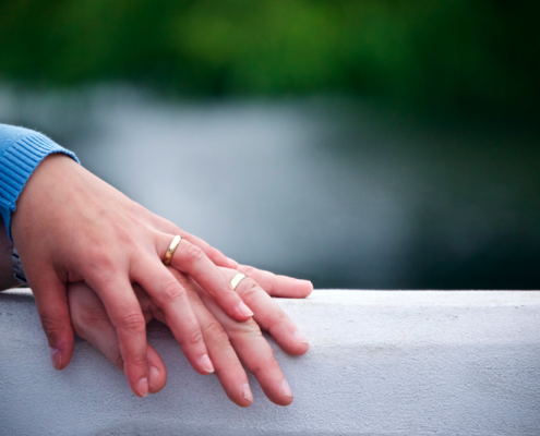 two hands with wedding rings
