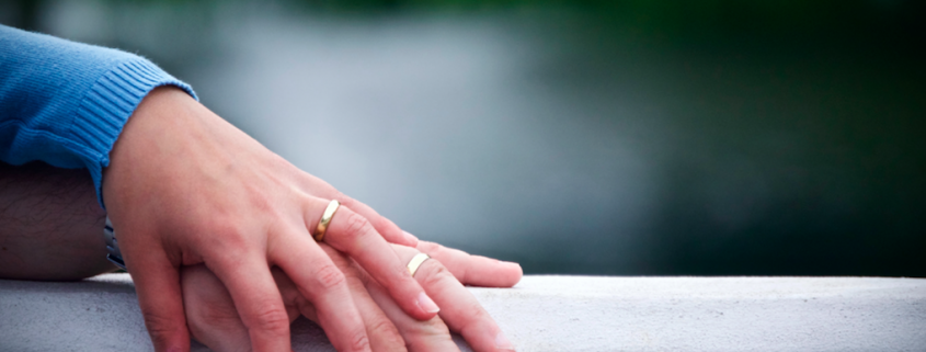 two hands with wedding rings