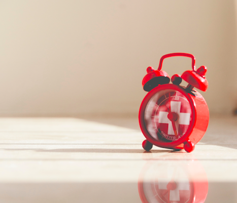 alarm clock with red cross on it