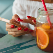 woman reading on phone with red nails