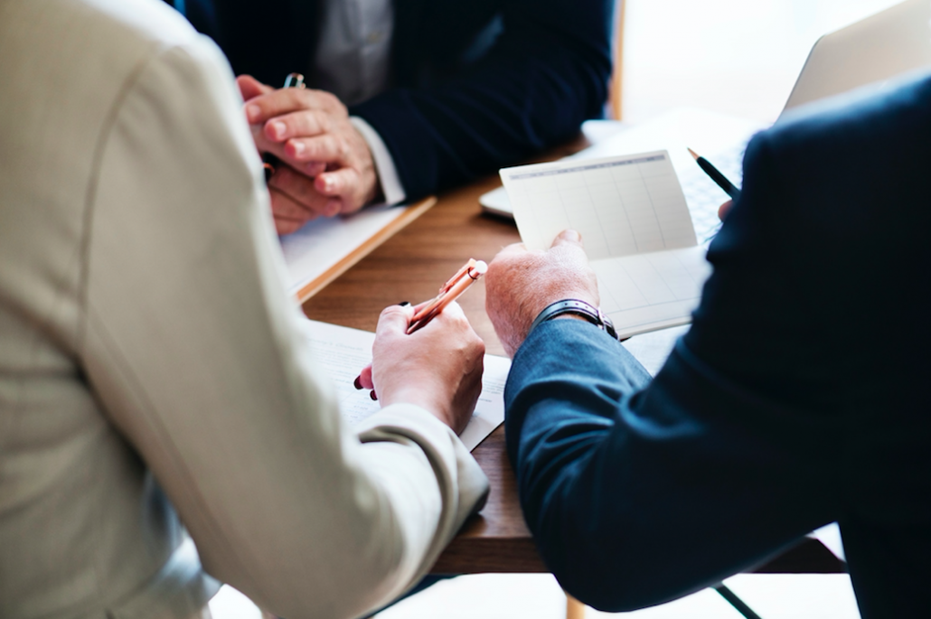 People having a meeting at a desk with papers