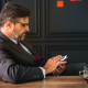 Man sitting at conference table with phone