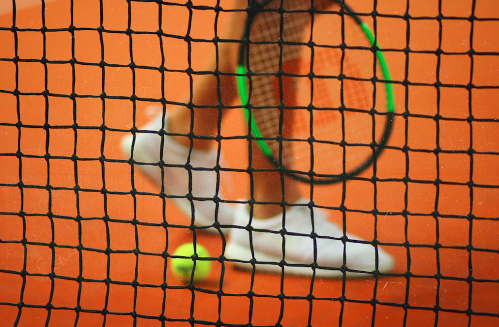 tennis shoes on red court