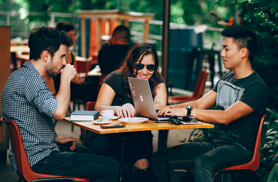 three employees talking at cafe table