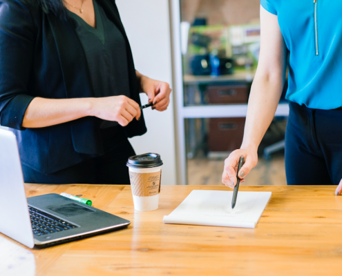 Two woman at board meeting table