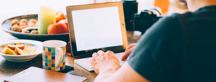 man on tablet at table